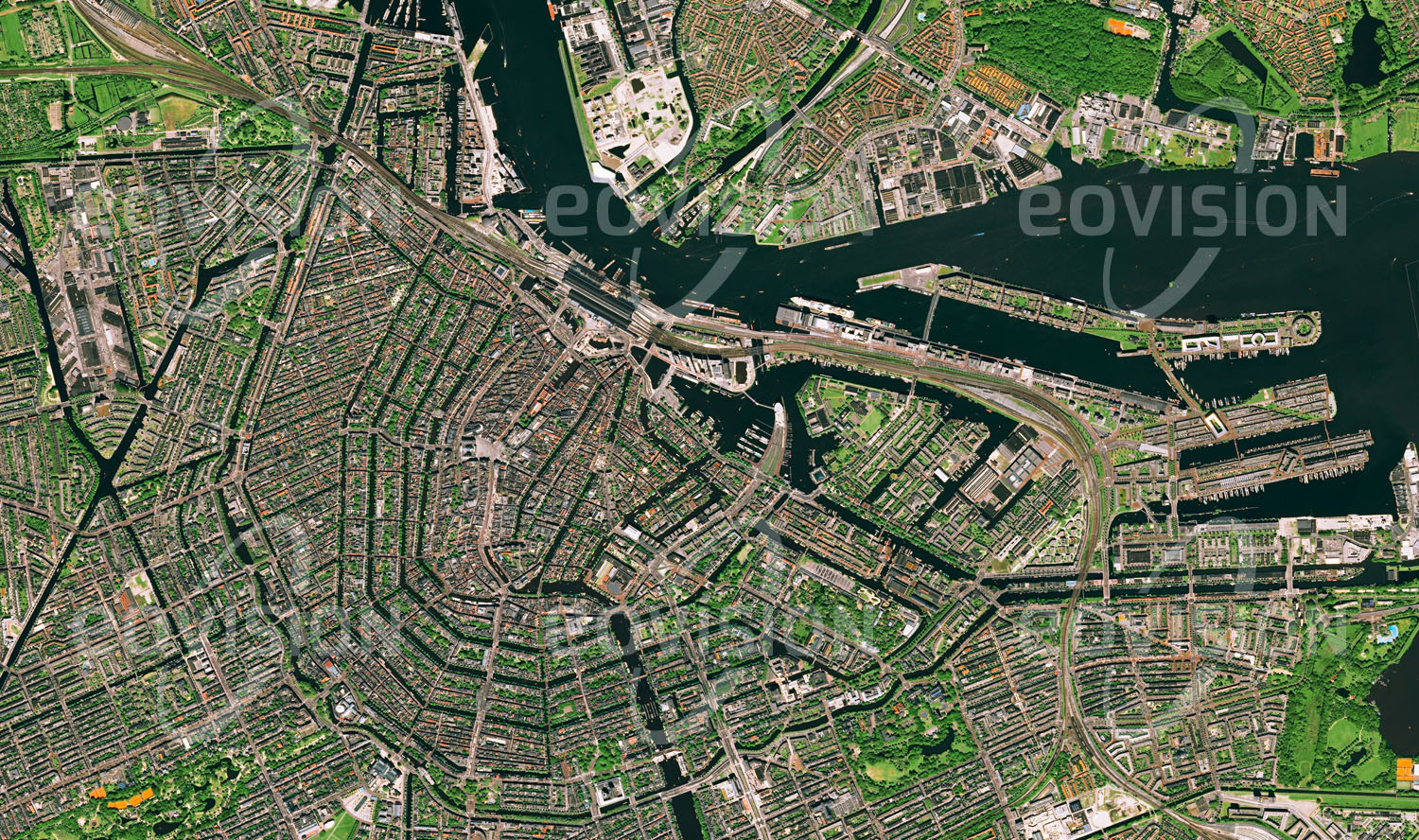 Das Satellitenbild 'AMSTERDAM, Niederlande' ist dem Bildband "Cities - Brennpunkte der Menschheit" entnommen. Die Grachten der niederländischen Hauptstadt mit ihrem geometrischen Muster waren lange Zeit die Haupttransportwege von Amsterdam. Die gesamte Stadt wurde wegen des feuchten und sandigen Untergrundes auf Pfählen errichtet. Die Seele der Stadt ist tolerant, frech und manchmal etwas verrückt. Hier entstehen neue Viertel mit avantgardistischer Architektur. Im alten Hafengebiet befinden sich heute trendige Restaurants und Lounges in coolen Industriekomplexen