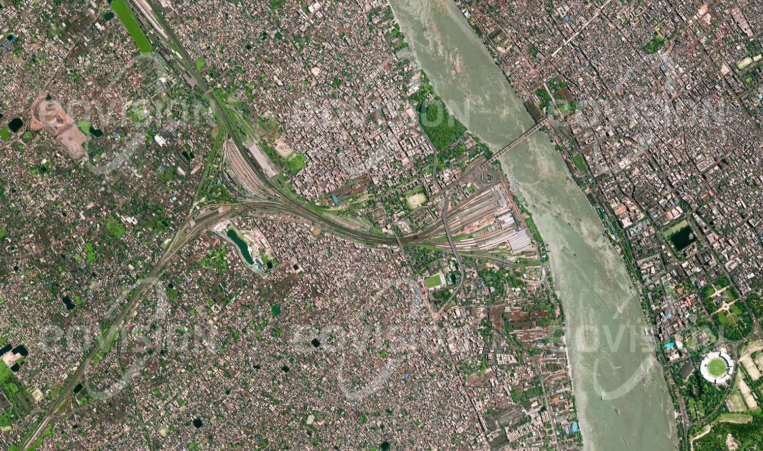 Das Satellitenbild 'KALKUTTA, Indien' ist dem Bildband "Cities - Brennpunkte der Menschheit" entnommen. Die Howrah-Station am Ufer des Hugli, eines der Mündungsarme des Ganges, ist ein wichtiges Eingangstor nach Kolkata (Kalkutta). Täglich benützen 1,3 Millionen Passagiere diesen Bahnhof, der als ältester Indiens im Jahr 1854 eröffnet wurde und ursprünglich die Verbindung zur Kohlenregion Bardhaman herstellte. Mit 28 Gleisen ist er einer der weltweit größten Bahnhöfe.