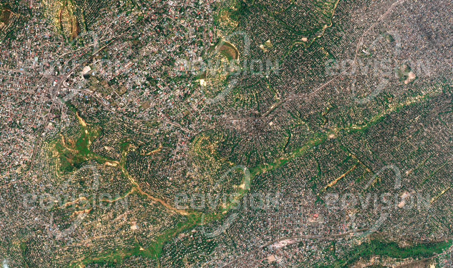 Das Satellitenbild 'KINSHASA, Kongo, DRC' ist dem Bildband "Cities - Brennpunkte der Menschheit" entnommen. Die Talböden im hügeligen Gelände der Vorstädte von Kinshasa sind während der Regenzeit häufig überflutet und eignen sich daher nicht zur Bebauung. Die Hügel selbst dagegen sind über viele Quadratkilometer mit kleinen Häusern bedeckt. Die Gärten werden für den Anbau von Obst und Gemüse für den Eigenbedarf genutzt.