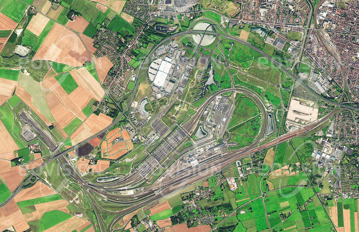 Das Satellitenbild 'CALAIS, Frankreich' ist dem Bildband "Europa - Kontinent der Vielfalt" entnommen. Calais liegt gegenüber dem englischen Dover nahe an der engsten Stelle des Ärmelkanals und war daher seit jeher ein wichtiger Verbindungspunkt zwischen dem europäischen Kontinent und England. Der Hafen von Calais ist der zweitgrößte Passagierhafen Europas. Diese Rolle wurde durch den 1994 eröff­neten und 50 Kilometer langen Eurotunnel noch verstärkt. In den letzten Jahren fand sich Calais in den Medien wieder, weil hier zahlreiche Flüchtlinge landeten, die nach Großbritannien gelangen wollten.n