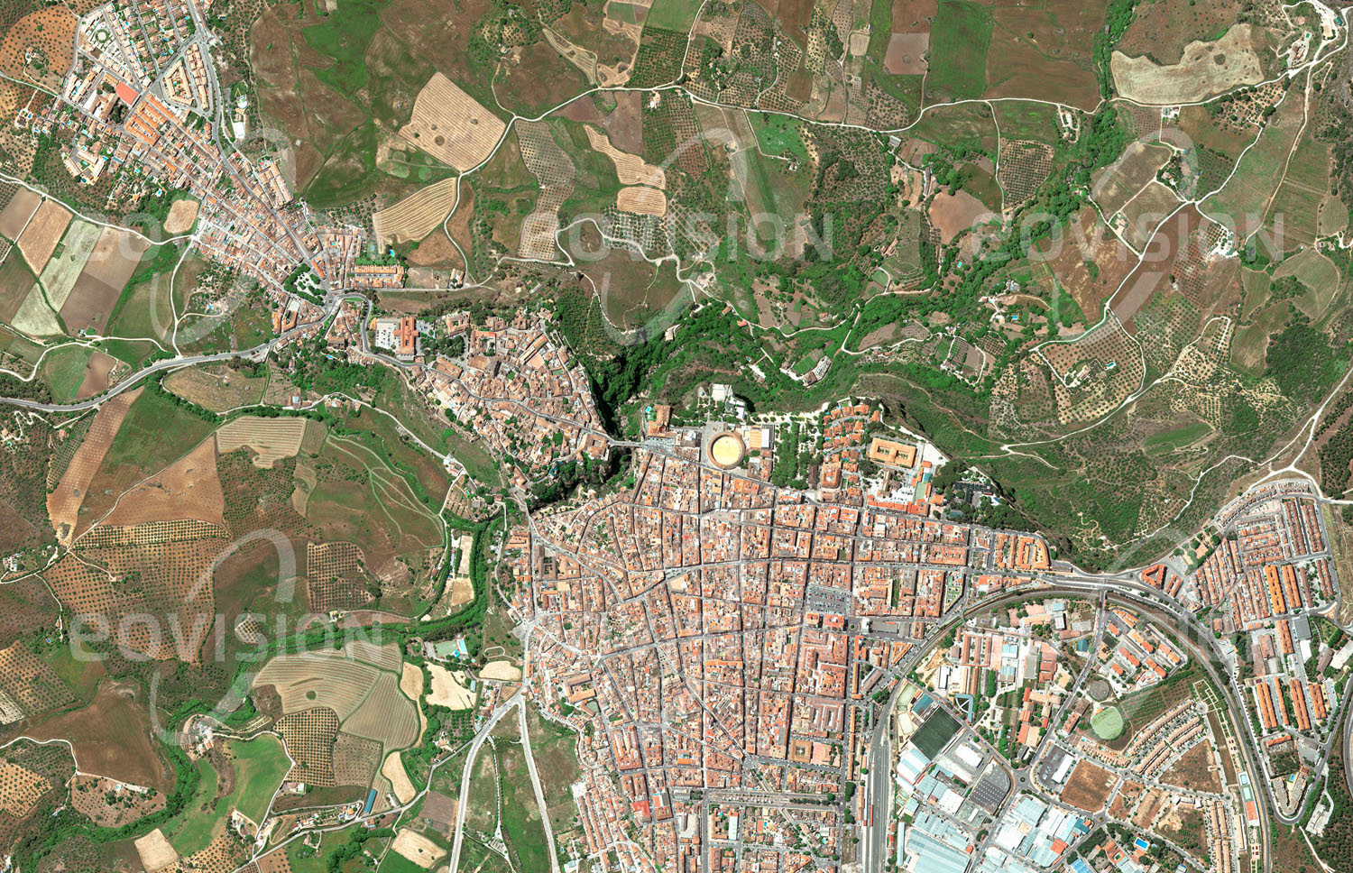 Das Satellitenbild 'RONDA, Spanien' ist dem Bildband "Europa - Kontinent der Vielfalt" entnommen. Die andalusische Stadt Ronda ist ein Beispiel dafür, wie sich die Geschichte einer Stadt in ihrer Struktur spiegelt. Seit der Altsteinzeit besiedelt, errichteten schon die Römer und später Araber Befestigungen auf dem unzugänglichen Felsen. Erst im 18. Jahrhundert wurde er durch die Brücke Puente Nuevo mit der Neustadt auf der benachbarten Hochebene verbunden. n