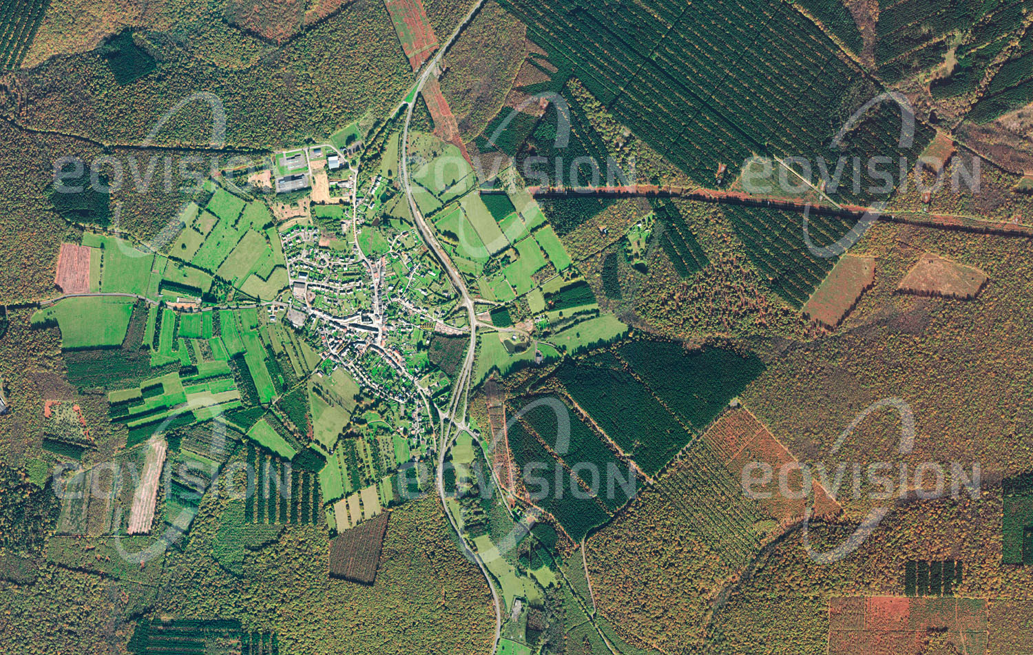 Das Satellitenbild 'LES MAZURES, Frankreich' ist dem Bildband "Europa - Kontinent der Vielfalt" entnommen. Schon im frühen 12. Jahrhundert scheint der Name Les Mazures erstmals urkundlich auf. Der kleine Ort liegt mitten im bewaldeten Teil der Ardennen nahe der Grenze zu Belgien. Um die Siedlung mit etwa 950 Einwohnern erstreckt sich eine kompakte Rodungsinsel mit kleinräumigen landwirtschaftlichen Flächen. Die ausgedehnten Wälder wurden früher zur Erzeugung von Holzkohle für die Eisenverhüttung genutzt und sind auch heute der wichtigste Wirtschaftsfaktor von Les Mazures.n