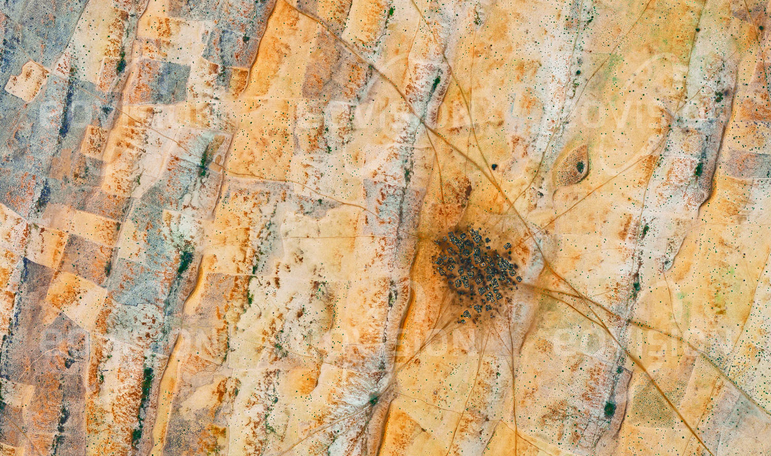 Das Satellitenbild 'TAWILAH, Sudan' ist dem Bildband "Human Footprint - Satellitenbilder dokumentieren menschliches Handeln" entnommen. Durch Einfriedung der Grundstücke schützen die Bewohner dieses sudanesischen Dorfes inmitten weitgestreckter Sanddünen ihre Höfe vor Sandverwehungen.