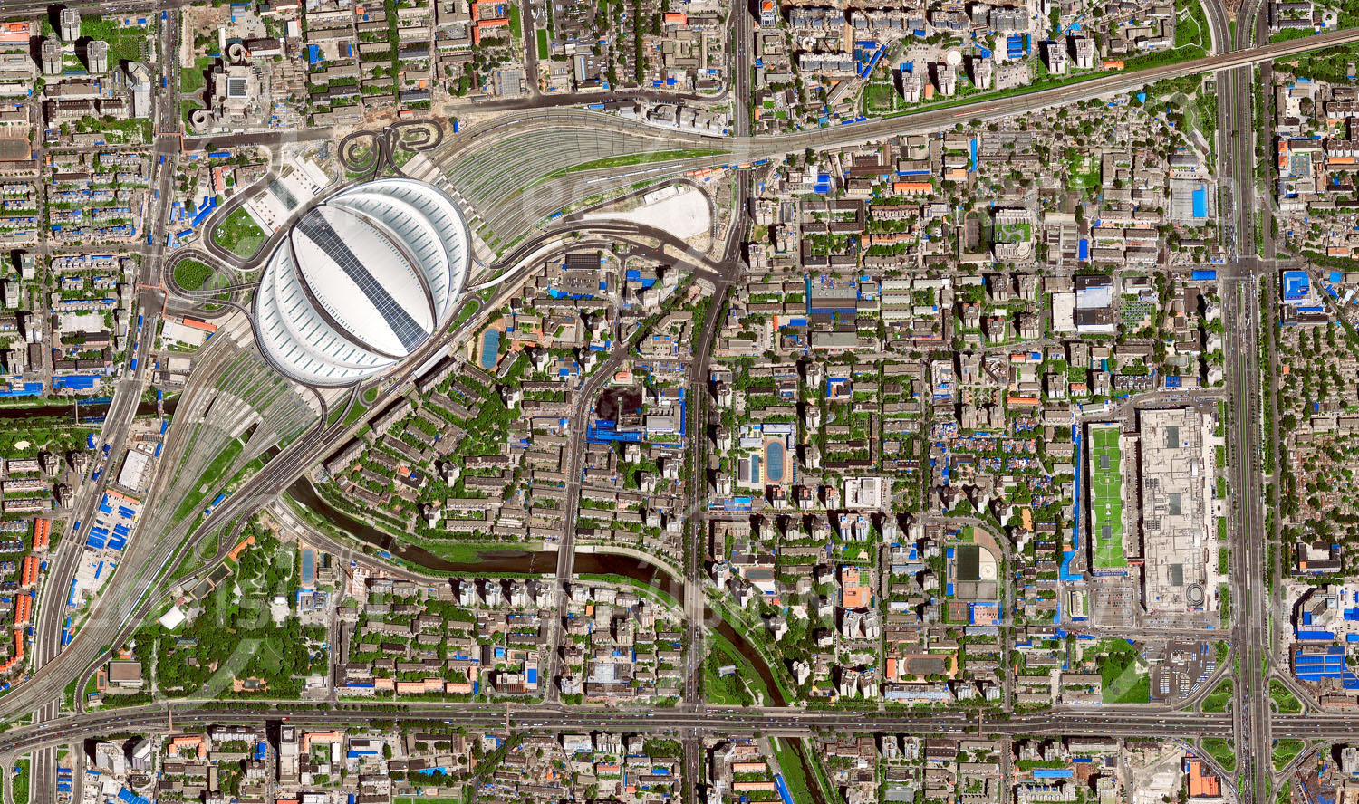 Das Satellitenbild 'BEIJING, China' ist dem Bildband "Human Footprint - Satellitenbilder dokumentieren menschliches Handeln" entnommen. In die Dachkonstruktion des 2008 anlässlich der olympischen Sommerspiele eröffneten Südbahnhofes sind Solarmodule integriert, die das Gebäude mit elektrischer Energie versorgen.