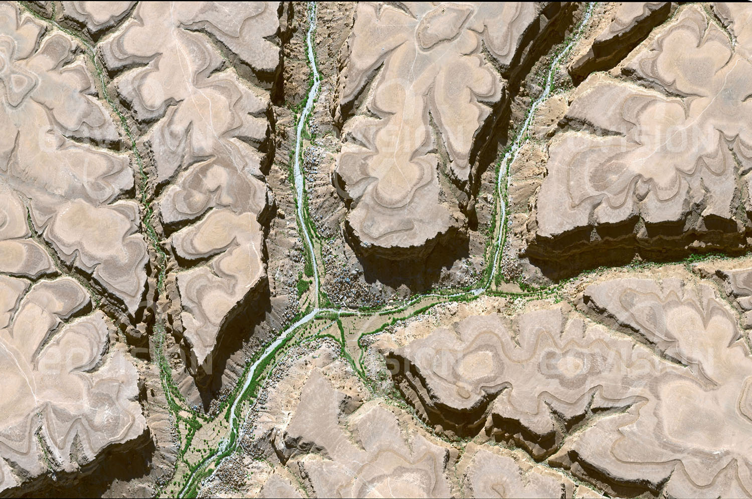 Das Satellitenbild 'AL-KHURAIBAH, Jemen' ist dem Bildband "New Human Footprint - Unsere Welt im Umbruch" entnommen. Die gebirgige Region im Hadramaut liegt zwischen 2000 bis 2500 Metern Höhe. Die Gebirgsdecke wird von Sedimentlagen gebildet, die infolge der Erosion wie Höhenlinien erscheinen. Nur am Grund der Wadis ist Wasser zu finden, daher sind nur die Täler besiedelt. Die fruchtbarsten Bereiche im Talgrund werden für den Anbau von Sorghum, Mais und Kath genutzt.