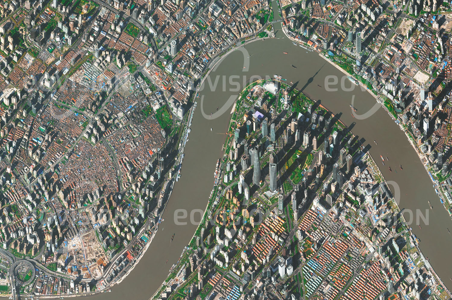 Das Satellitenbild 'SHANGHAI - PUDONG, China' ist dem Bildband "New Human Footprint - Unsere Welt im Umbruch" entnommen. Seit der wirtschaftlichen Öffnung in den 1990er Jahren hat sich die Bevölkerung Shanghais fast verdoppelt, sodass die Stadt heute mit mehr als 24 Millionen Einwohnern die bevölkerungsreichste Chinas ist. Dem zunehmenden Platzbedarf für Wohn- und Bürogebäude werden auch die letzten der traditionellen, gemischten Wohn- und Gewerbeviertel mit ihren niedrigen Häusern den zeitgemäßen Hochhäusern weichen müssen.