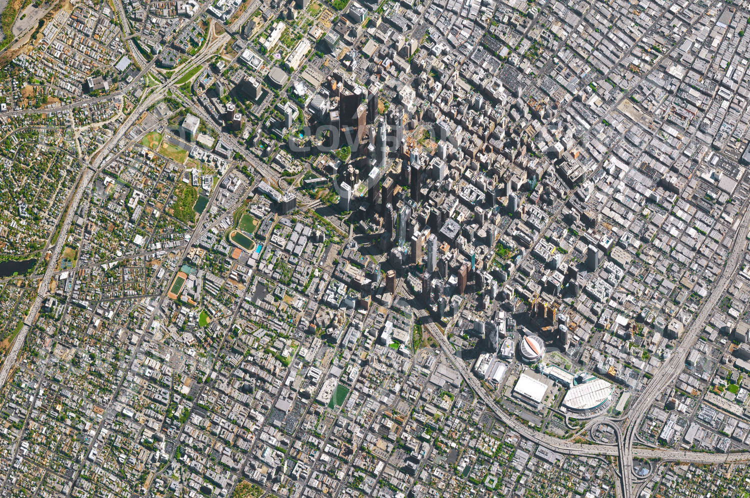 Das Satellitenbild 'LOS ANGELES, USA' ist dem Bildband "New Human Footprint - Unsere Welt im Umbruch" entnommen. Infolge der Nähe von Los Angeles zur San-Andreas-Spalte treten hier immer wieder schwere Erdbeben auf, wie zuletzt 1994. Daher ist die Anzahl von Wolkenkratzern sehr gering, mit der Folge eines großen Flä­chenbedarfs für Wohnbau und auch für die Verkehrsinfrastruktur. Trotz breiter Straßen mit bis zu 15 Spuren, die in Kreuzungen in mehreren Stockwerken übereinander geführt werden, sind Staus in Los Angeles an der Ta­gesordnung.