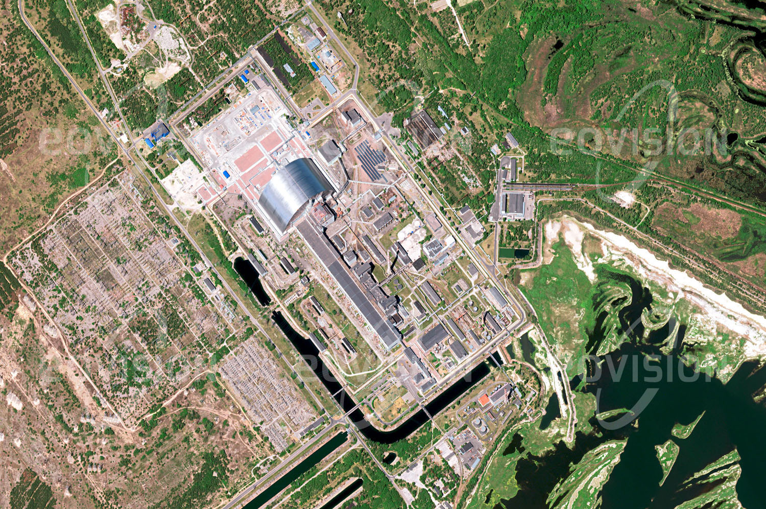 Das Satellitenbild 'TSCHERNOBYL, Ukraine' ist dem Bildband "New Human Footprint - Unsere Welt im Umbruch" entnommen. Das heute ukrainische Prypjat ist ein promi­nentes Beispiel für negative Auswirkungen von Aktivitäten des Menschen auf seine unmittelbare Umwelt. Die Stadt, die erst 1970 für die Arbeiter des Kernkraftwerks Tschernobyl gegründet wurde, musste nach der nuklearen Katastrophe im nur vier Kilometer entfernt gelegenen Kraftwerk im Jahr 1986 aufgegeben werden. Zu diesem Zeitpunkt hatte Prypjat fast 50.000 Einwohner. Um die weitere Verbreitung radio­aktiven Materials zu verhindern, wurden die Kraftwerksruine und der darüber errichtete „Sarkophag“ von einer zusätzlichen Hülle bedeckt, die 2016 auf Sch