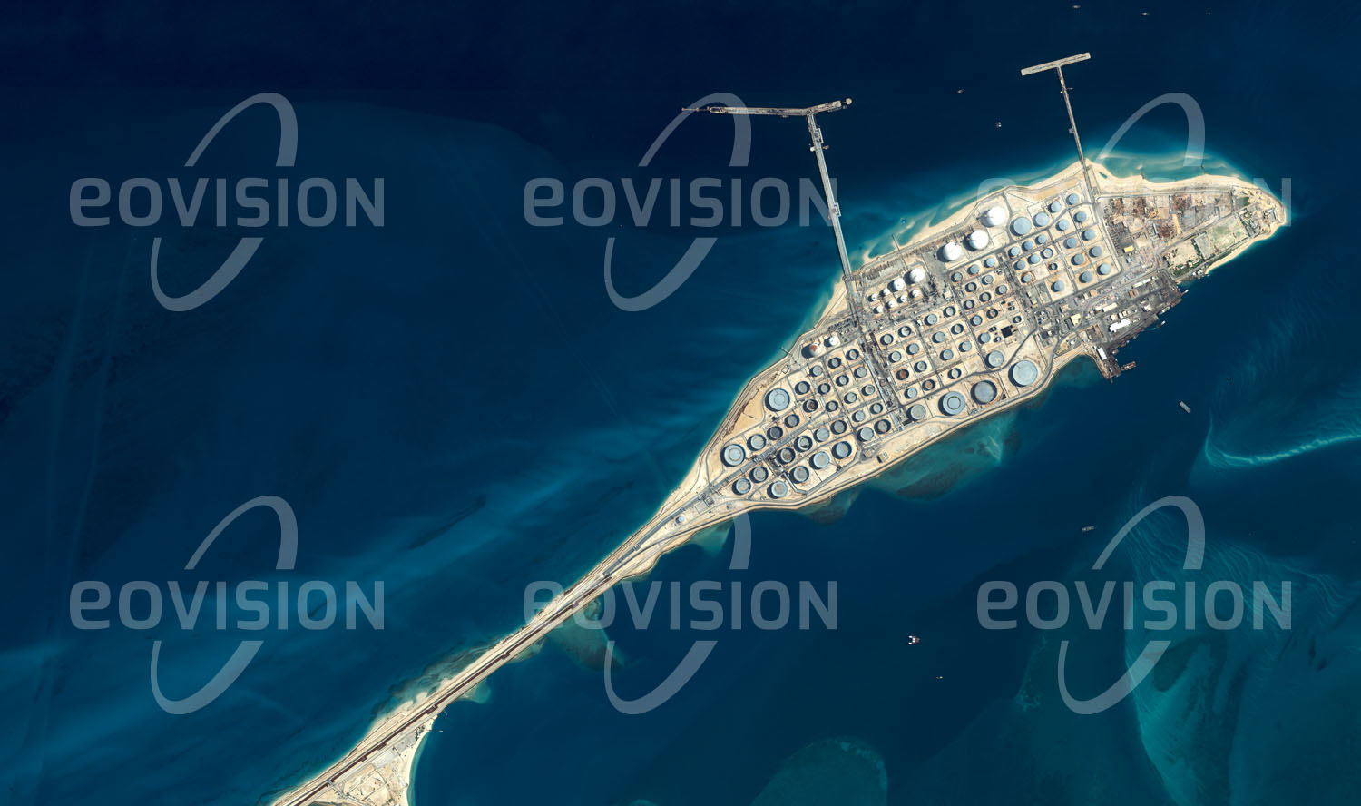 Das Satellitenbild 'RA'S TANURA, Saudi-Arabien' ist dem Bildband "one earth - Limitierte Ausgabe" entnommen. Nahe dem saudi-arabischen Jubail liegt die Halbinsel Ra's Tanura, auf der eine Erdölraffinerie und der weltweit größte Ölverladehafen errichtet wurden. An den Piers und an im Meer vorgelagerten Pumpstationen können täglich bis zu 950 Millionen Liter Erdöl in Tanker gepumpt werden.