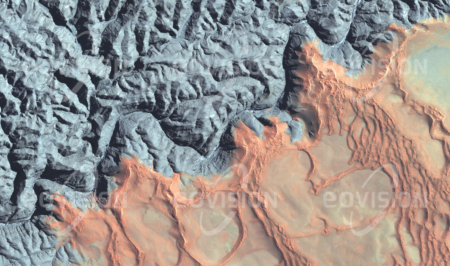 Das Satellitenbild 'KUISEB CANYON, Namibia' ist dem Bildband "Untouched Nature - Naturlandschaften in Satellitenbildern" entnommen. Der nur zeitweise fließende Kuiseb in Namibia bildet eine Grenze zwischen der Sandwüste Namib und der im Norden anschließenden Felswüste. Die scharfe Grenze entsteht dadurch, dass der Fluss den nach Norden gewehten Sand abtransportiert. In seinem Mittellauf durchfließt der Kuiseb die Hakosberge in einem bis zu 200 Meter tief eingeschnittenen Canyon. Die durch Oxidation des Eisens rötliche Farbe des Sands ist für die Namib charakteristisch. Damit kontrastiert sie, wie hier am Kuiseb Canyon, deutlich mit der umliegenden Landschaft.