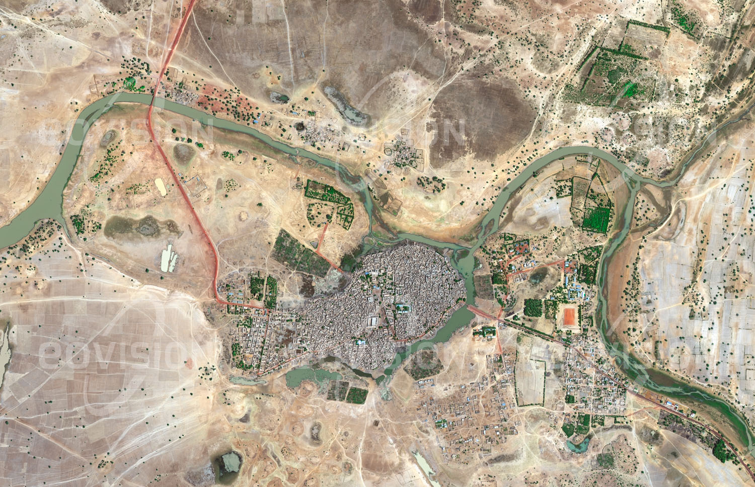 Das Satellitenbild 'DJENNÉ, Mali' ist dem Bildband "Wüsten - Lebensraum der Extreme" entnommen. Die Geschichte der Stadt im Süden des Niger-Binnendeltas ist eng mit jener Timbuktus verbunden. Als traditionell wichtiger Handelsstützpunkt beherbergt sie heute etwa 33.000 Einwohner und ist vor allem für die historischen Gebäude in Lehmbauweise bekannt. Unter diesen sticht die 1907 erbaute Große Moschee als größtes und eines der bedeutendsten Bauwerke des sudanischen Stils heraus. Mit der gesamten Altstadt ist diese Teil des UNESCO-Welterbes.