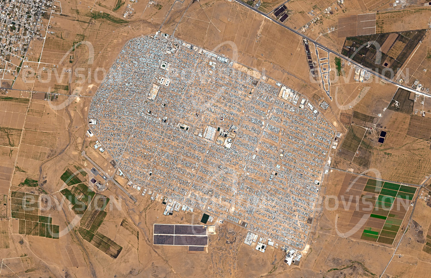 Das Satellitenbild 'AZ-ZAATARI, Jordanien' ist dem Bildband "Wüsten - Lebensraum der Extreme" entnommen. Kriegerische Konflikte sind der häufigste Grund, dass Menschen ihre Heimat verlassen. Wie die Konflikte selbst sind daher auch Flüchtlingslager kein neues Phänomen. Das für maximal 80.000 Bewohner geplante Az-Zaatari im Norden Jordaniens gehört zu den größten Flüchtlingslagern der Welt. Es entstand 2012 als Folge des syrischen Bürgerkriegs, durch den bis 2015 fast 12 Millionen Menschen vertrieben wurden. Im März 2013 beherbergte das Lager sogar mehr als 156.000 Menschen. Unter der Leitung des UNHCR (Flüchtlingswerk der Vereinten Nationen) hat sich Az-Zataari zu einer eigenen Stadt entwickelt.