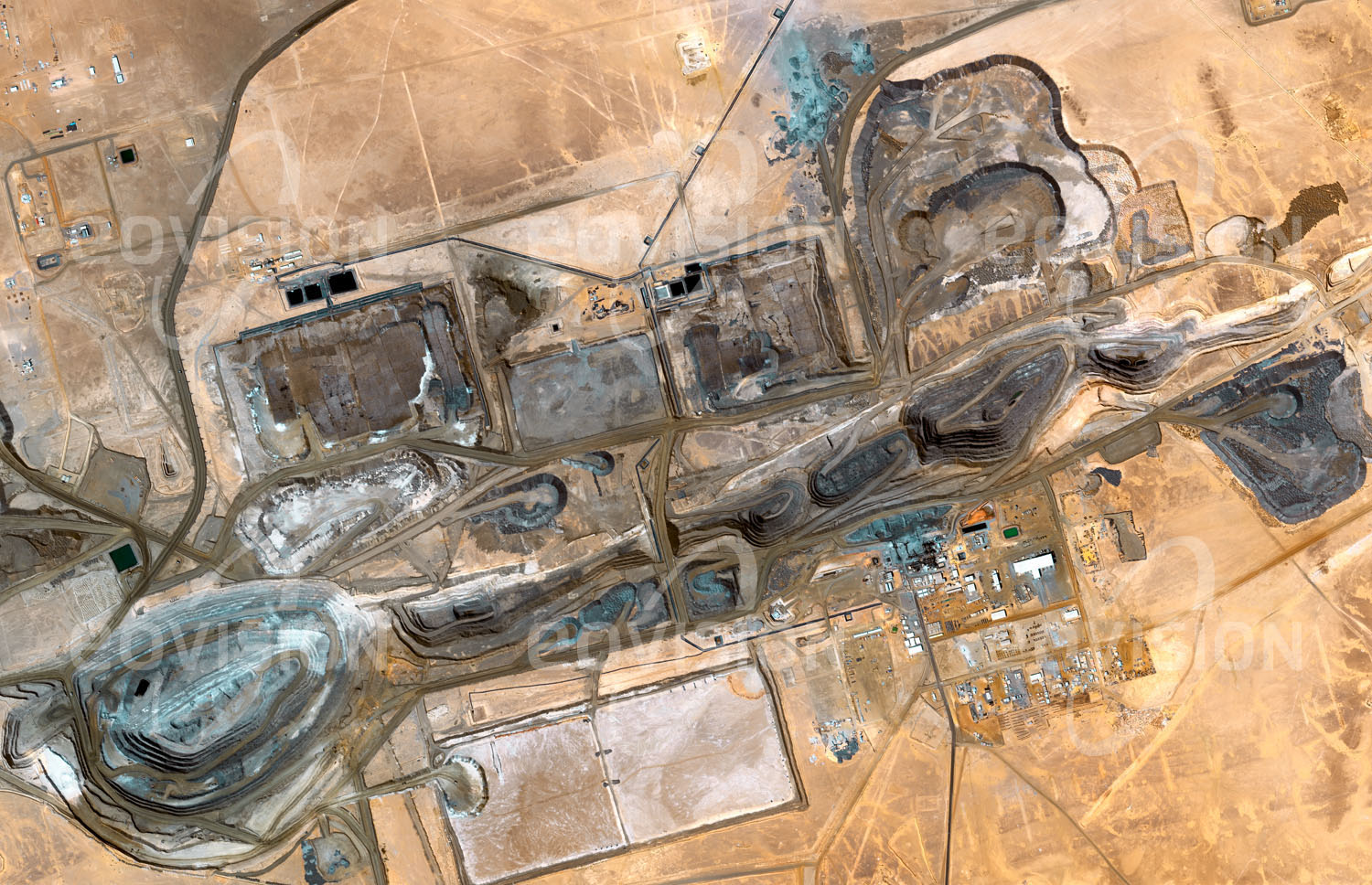 Das Satellitenbild 'TASIAST-MINE, Mauretanien' ist dem Bildband "Wüsten - Lebensraum der Extreme" entnommen. Im Tagebau der Tasiast-Mine im Westen Mauretaniens wird seit 2008 Gold gefördert. Aufgrund hoher Anlaufkosten war der Start schwierig, insgesamt werden hier jedoch etwa 7,5 Millionen Unzen (230 Tonnen) förderbares Gold erwartet. Für jedes Gramm Gold muss fast eine Tonne Gestein verarbeitet werden.