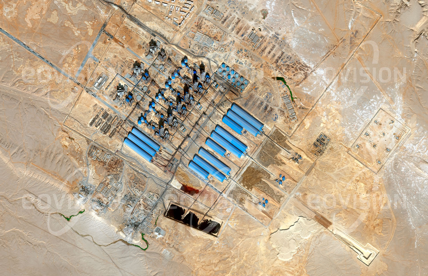 Das Satellitenbild 'BENI SUWIF, Ägypten' ist dem Bildband "Wüsten - Lebensraum der Extreme" entnommen. Zement ist einer der wichtigsten Grundstoffe für die Bauindustrie. Weltweit wurden zuletzt jährlich mehr als vier Milliarden Tonnen Zement produziert. Die Hauptbestandteile sind dabei Kalk und Ton. In der neuen Zementfabrik in Beni Suwif werden in sechs langen, liegend rotierenden Öfen bei bis zu 1450 °C jeden Tag 6000 Tonnen Zement erzeugt. Zu den Problemen der Zementproduktion gehört, dass große Mengen CO2 freigesetzt werden. Weltweit sind dies etwa acht Prozent der gesamten Treibhausgasemissionen.