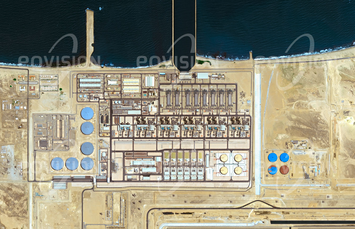 Das Satellitenbild 'RAS AL-KHAIR, Saudi-Arabien' ist dem Bildband "Wüsten - Lebensraum der Extreme" entnommen. Aufgrund fehlender Süßwasservorkommen deckt Saudi-Arabien heute etwa 70 Prozent seines Wasserbedarfs aus dem Meer. Die mit einem Kraftwerk gekoppelte Entsalzungsanlage Ras al-Khair am Persischen Golf ist die größte dieser Art. Seit 2014 in Betrieb, produziert sie 2400 MW Strom, von denen 200 MW für die Entsalzung verbraucht werden. Mittels mehrstufiger Entspannungsverdampfung und Umkehrosmose werden täglich mehr als eine Million Kubikmeter Trinkwasser erzeugt und durch Pipelines nach Riad und Hafr al-Batin geliefert.