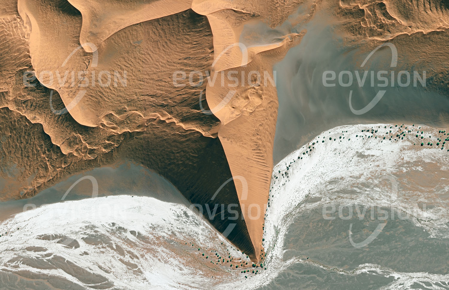 Das Satellitenbild 'SOSSUSVLEI, Namibia' ist dem Bildband "Wüsten - Lebensraum der Extreme" entnommen. Das Sossusvlei ist eine von roten Sanddünen umgebene Salztonebene im Namib-Naukluft-Nationalpark in der südlichen Namib. Hier versiegt der nur zeitweise Wasser führende Tsauchab. Die Dünen dieser Wüste gehören zu den höchsten der Erde und erreichen Höhen von mehr als 300 Metern. Die Region gehört zum UNESCO-Welterbe und ist eines der wichtigsten Tourismusziele Namibias.