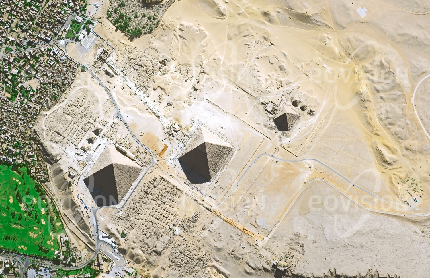 Das Satellitenbild 'GIZEH - PYRAMIDEN, Ägypten' ist dem Bildband "Wüsten - Lebensraum der Extreme" entnommen. Zu den spektakulärsten Spuren alter Zivilisationen gehören die Pyramiden der ägyptischen Hochkultur. Besonders charakteristisch sind die vor 4500 Jahren erbauten drei großen Pyramiden bei Gizeh. Fünf Kilometer südwestlich des Kairoer Stadtzentrums am Rand der Wüste über dem Niltal gelegen waren sie schon Teil der sieben Weltwunder der Antike. Die von der Sphinx begleiteten Grabmäler der Pharaonen Cheops, Chefren und Mykerinos lösen durch ihre Größe und Geometrie auch heute noch Staunen aus, wobei die genaue Vorgangsweise beim Bau nach wie vor unbekannt ist.